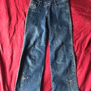 Blå jeansbyxor med broderade detaljer - Ett par blå jeansbyxor med broderade detaljer vid bensluten. Skriv om ni vill ha mer bilder på de!