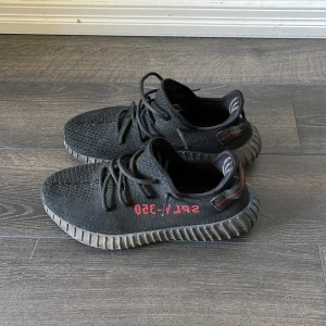 Yeezy Boost 350 V2 Black/Red - Säljer ett par Yeezy V2 då de bara ligger och dammar, inte använt de på några år. Inte original! Använt de ett par gånger, så de är lite smutsiga på sulan och inte orkat tvätta. Men det är nog rätt lätt att få de rena. Storlek: 44 Skick: 9/10