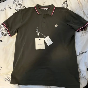 Moncler piké  - Säljer min helt nya moncler piké då den va för stor, står storlek XXL men upplever den mer som en L/XL.  Har inget kvitto kvar då den är köpt i butik, men äkthetsbevis finns genom taggen i tröjan och prislappen. Hör av dig om du har fler frågor☺️