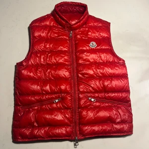 Moncler gui - Tjena! Säljer en moncler gui väst! Den är i toppskick👍🏼 Sjukt snygg röd färg, perfekt nu inför våren🤩 