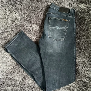 Nudie jeans - Ett par asfeta jeans från Nudie 🤩 Jeansen är i en snygg mörkblå färg och är i topp skick 🙌 Storlek 34/32, slimfit modell. Det är bara att höra av sig vid frågor eller funderingar, pris är ej hugget i sten 💸