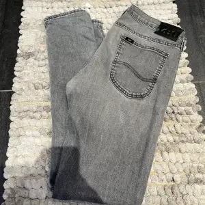 Riktigt schyssta jeans från Lee i en snygg grå färg, storlek W32 L32, fint skick (förutom en liten lagning under gylfen)