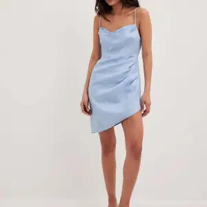 Oanvänd klänning från na-kd. Storlek 34. Klänningen är superfin ljusblå färg i riktigt linne material.