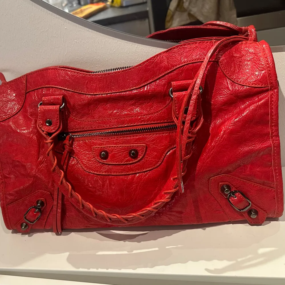 Balenciaga liknande väska i en häftig röd färg. Väskan är ganska rymlig så kan vara typ en skolväska. Använder tyvärr inte den då färgen inte passar mig. Inte äkta!!. Väskor.
