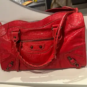 Balenciaga liknande väska i en häftig röd färg. Väskan är ganska rymlig så kan vara typ en skolväska. Använder tyvärr inte den då färgen inte passar mig. Inte äkta!!