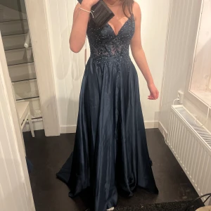 Balklänning - Säljer denna klänning då jag valt att ha en annan på balen. Den är helt ny med lappen kvar! Älskar verkligen denna men kan tänka mig att sälja den för ett bra pris🫶🫶 Klänningen är gjord av satin, i en marinblåfärg och spets med glitter🥰 Stl: 32/34