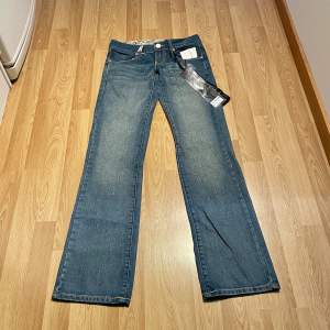 (17) ljusblåa lågmidjade bootcut jeans helt nya med lappar kvar. Midjemått rakt över: 36cm, innerbenslängd: 84cm 🩵