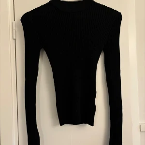 Topp - Glittrig topp från ginatricot , långarmad med slits längst ner. Väligt fin till alla tillfällen. Storlek 38