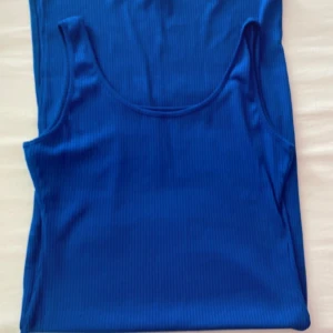 Blå ribbad linnetopp - klänningen har en enkel och stilren look, perfekt för varma dagar.