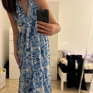Blommig klänning - Säljer denna mamma-mia inspirerande klänningen från Zara då den är för stor. Den har fickor på båda sidorna och är aldrig använd. Den har fortfarande prislappen på sig!🩷