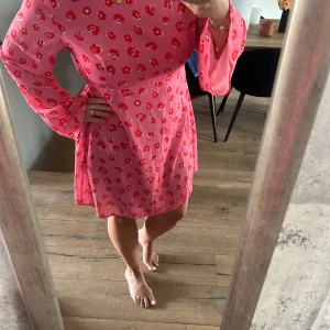 Rosa klänning med blommor  - Härlig sommarklänning i storlek 42 säljes, bra skick. Endast använd ett fåtal gånger 