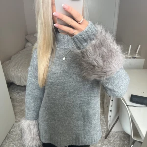 Stickad tröja med päls - Säljer denna grå stickade tröja med päls vid ärmarna. Har du någon fråga är det bara att höra av dig🫶🏻