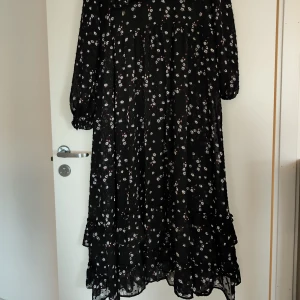 Långklänning  - Svart klänning med små blommor. Använd ett fåtal gånger.