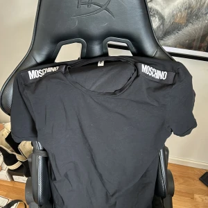 Mochino t shirt - Moschino t shir köpt från room 1006 på emporia. Köpt för 899 Säljer pågrund av ingen användning. Sitter väldigt bra ganska stor för storlek m. Så om du har L funkar det perfekt. M/L i storlek är bra 