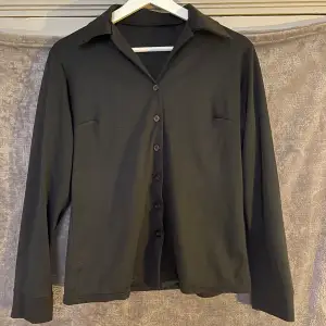 Perfekt svart skjorta, otroligt skönt material. Halvlånga ärmar.  Uppskattar storleken till 36-38. Bra skick!