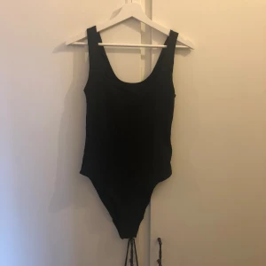 Svart body - Fin svart body med knappar i skrevet, kommer aldrig till användning då jag har större byst och den trycker emot, fint skick och rekommenderar att man har lite mindre byst