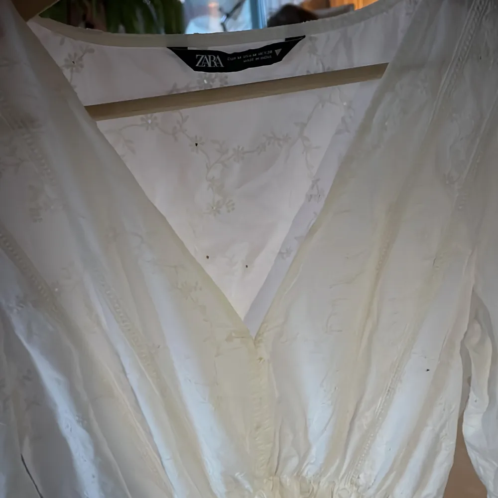 Superfin vit klänning från Zara med söt blombrodyr. Den här långa lite puffiga ärmar och fin ringning vid halsen. Använd sparsamt så den är nästan i nyskick. . Klänningar.