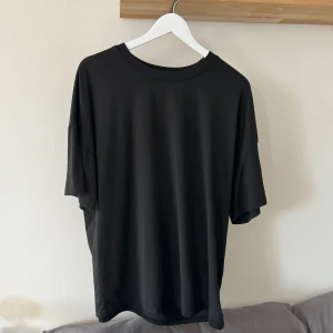 Svart t-shirt med tryck - Svart t-shirt med tryck på ryggen. 