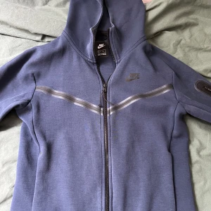 Nike tech Navy set - Tröjan har lite slitage som man ser på bilden, byxorna är dock som nya. Byxorna är i storleken Small och tröjan i XS. Kan säljas separat. Byxorna 400 Koftan 400.