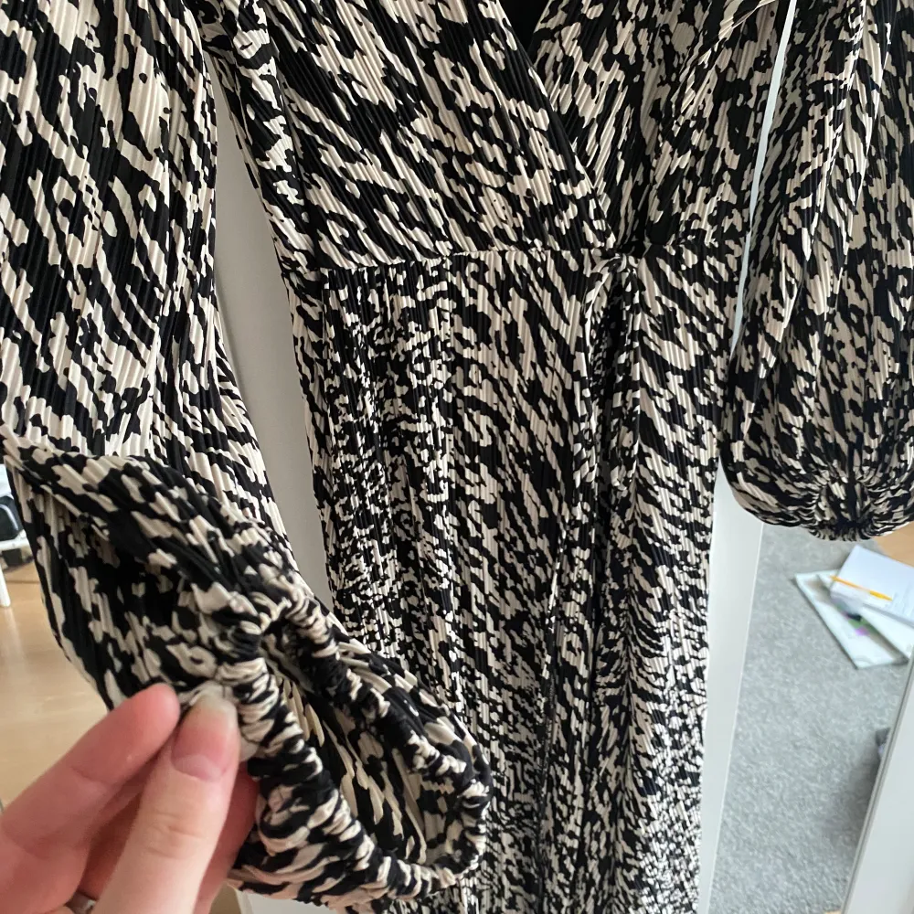 En mönstrad klänning från H&M. Klänningen är omlott och ska knytas i midjan. Sam att den har detaljer vid ärmen.  Den är använd en gång och helt som ny. Klänningar.