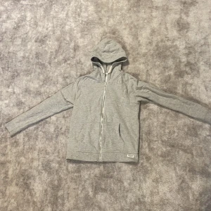 Grå hoodie - Säljer denna gråa zip up hoodien från lager 157 pågrund av att den är för liten. Den är snygg och har perfekt passform enligt mig. Använd cirka 1 gång. Storlek 160. Priset går att diskutera och om du har mer frågor är det bara att skriva! 