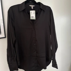 Svart blus  - Svart blus / skjorta från H&M, aldrig använd, är längre baktill än framtill 