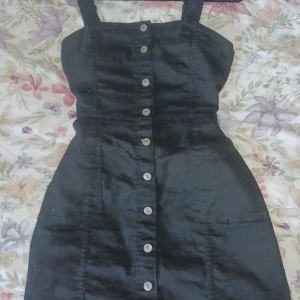 Svart jeansklänning - Jeansklänning med knappar och fickor framtill. Superhärlig till sommaren.  Är lite insydd vid midjan med det går att sprätta upp om justeras.   Köparen står för frakt💕