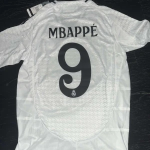 Mbappe Real Madrid tröja - En fantastiskt fin Mbappe Real Madrid tröja, säsong 2024/25. Helt ny och oanvänd. Tröjan är player version och har UCL patch på ärmen. 