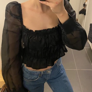Mesh cup blouse puffy sleeve - Donnaromina x NA-KD - Svart mesh topp med puffärmar. Storlek 40 men känns som S, stretchigt material. Använd handfull gånger, som ny✨💫 