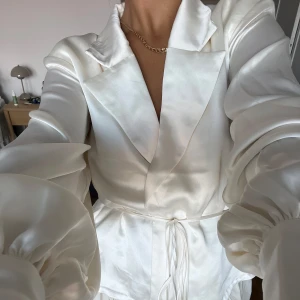 Blus från NA-KD - Jättefin knytblus från NA-KD. Använd ett fåtal gånger, jättebra skick. Ena axelvadden sitter inte helt fast men är enkelt att fixa när man har den på sig. Storlek 36, cremevit färg. Hör av er vid frågor! 💛