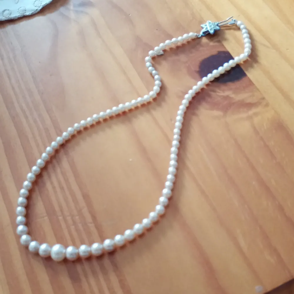 Vackert gammalt pärlcollier med vit gula pärlor och silverfärgade lås .. Accessoarer.