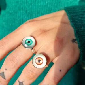 Unik ring-öga - Unik ring -öga●👁● Material: metal, glas.Stommen är ca 12mm i diameter, men kan göras mindre eller större, efter behov. Det är bara att försiktigt klämma ihop eller dra isär ändarna baktill, till önskad storlek. 