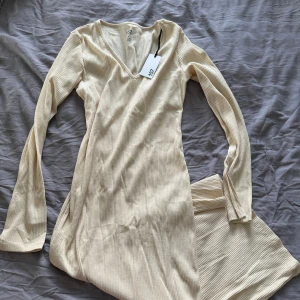 Helt ny långklänning  - Aldrig använd med lappen kvar. Långklänning från lager157, rubbat material och långa ärmar 