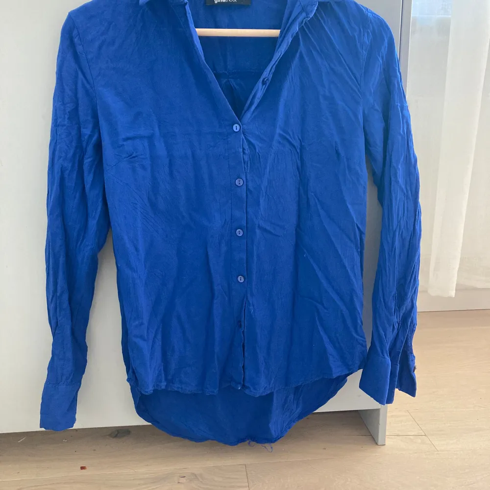 En blå skjorta i storlek 34 från Gina tricot. På bilderna är den väldigt skrynklig men det går att stryka. Bra skick💕. Skjortor.