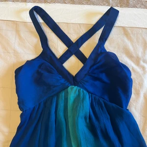 Jättefin lång sommarklänning - Så sjukt fin sommar klänning i blåa färger, perfekt till middag vid stranden när man är brun.  Omlott vid ryggen och så fin urringning🩵  Storlek 36 men kan även passa en 34 eller möjligtvis en 38 (dock mindre vid bysten)!