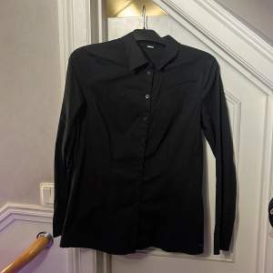 Enkel svart skjorta utan fickor. Står  storlek 44. Fint skick!