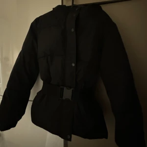 Jacka med bälte från nakd - Jättefin jacka från NAKD som är med huva och bälte. Gör så det blir så fin figur i midjan🤍🖤  Passar dem som har 34 också