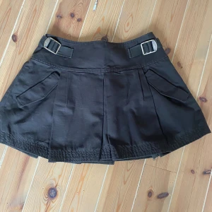 Kjol med spännen zara - Cool kjol från zara med mässingsfärgade spännen på sidorna. Sparsamt använd. 