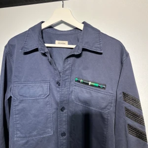 Zadig & voltaire overshirt  - Riktigt fräsch Overshirt från Zadig & Voltaire i storlek s men passar stor så mer som m. Den är i väldigt fint skick utan några defekter. Designen är lite vintage o sliten. 