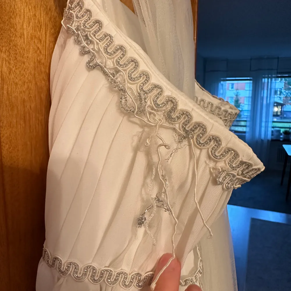 Säljer min brudklänning.Den är fantastiskt fin men har lite skavanker efter en lång dag.Det glittriga bandet har trissat upp sig på ett par ställen är du händig kan du fixa detta.Extra band medföljer.Även en sjal,väska och garderob.Behövs tvättas.. Mekot.