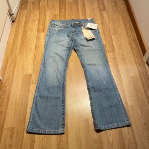 (24) Lågmidjade bootcut jeans med specialfickor helt nya med lappar kvar. Modellen är low bootcut Midjemått rakt över 38cm, innerbenslängd: 80 cm🩵
