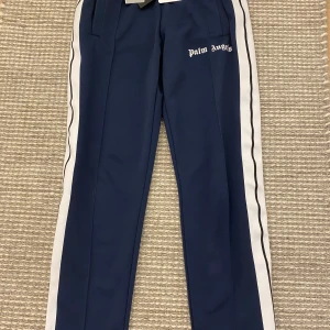  Palm Angels byxor mörkblå  - Palm Angels byxor mörkblå I storlek M med taggen kvar. Det är en liten fläck som man knappt ser  Sick 9/10 pris går att diskutera  Jag är 180cm och jag kan precis ha dom 