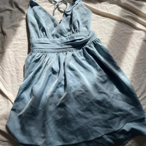 Miniklänning  - Klänning från NA-KD. Använd en gång. Har så man kan knyta en rosett på baksidan. 