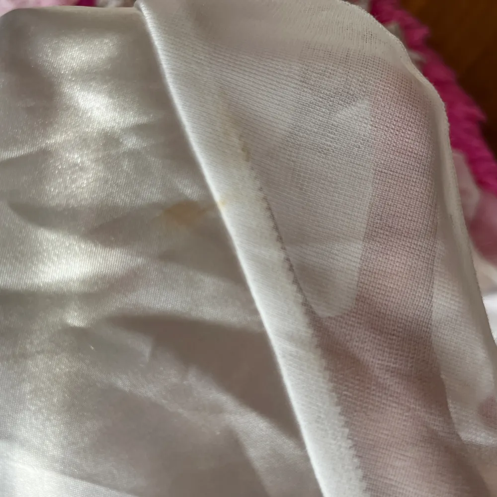 En till vit klänning i gräddvit med band runt midjan, dold dragkedja och öppen rygg. Använd en gång men det finns en liten smuts enligt bilden som går bort i tvätt. Jag har aldrig tvättat den.. Klänningar.