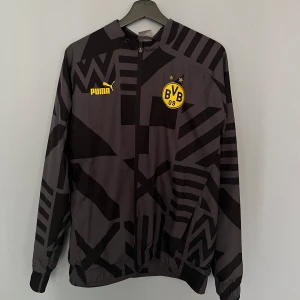 Dortmund pre-match jacka 2022/23 - Dortmund pre-match jacka från 2022/23 säsongen i perfekt skick, endast använd några fåtal gånger i storlek M  Jackan finns i Danderyd men går att hämtas upp i norra Stockholm!  Frakt fungerar också!