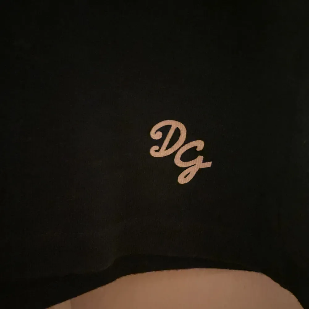 Svart T-shirt från Dolce & Gabbana köpt på humana. T-shirten funkar som en basic men har fina logo-detaljer här och där. Fint skick! Insydd lite i midjan så följer formerna fint💗står storlek 48 men passar som en M!. T-shirts.