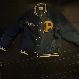 Pull and Bear varsity jacket - Blu varsity jacka från Pull and Bear. Använd några gånger men inga tecken på defekter. Hälften av jackan är gjord av blå jeans och andra halvan är mörkblått material.  Storlek Large