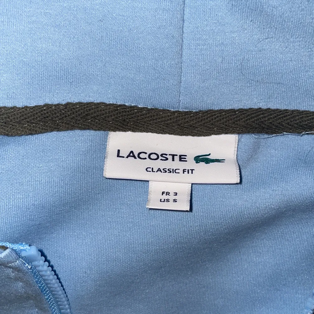 Lacoste zipp hoodie i storlek S.  Aldrig använts då den var för liten.. Hoodies.