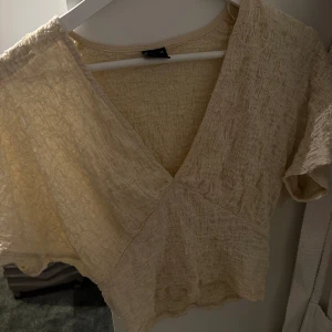 Topp Gina tricot  - V ringad blus/topp från Gina tricot med struktur i tyget, nyskick och jättefin till sommaren 😍😍krämvit