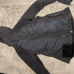 Sportjacka- H&M - Den är i storleken M. Är svart och vid ärmarna så är den ribbad. Har luva och är tunn i materialet. Använt den 2 gånger. Fint att ha till en sommarkväll. Väldigt sportigt jacka. 
